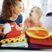 mama z córką wkładają do walizki apteczkę podróżną