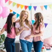 kobiety dotykają brzuch młodej mamy na baby shower