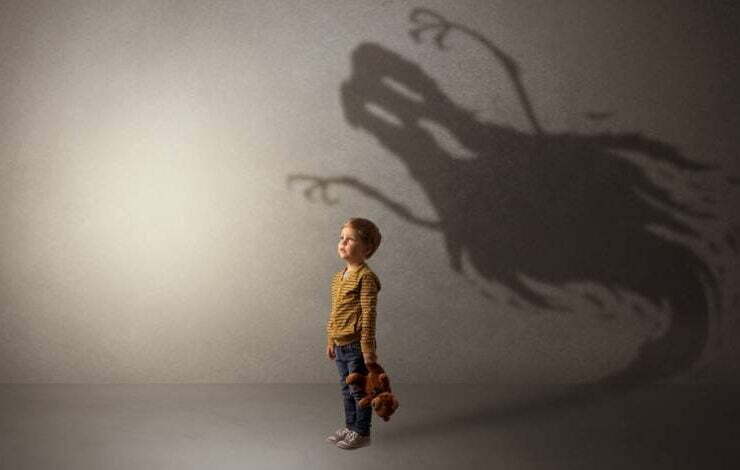 dziecko z misiem w ręku cień ducha na ścianie strach dziecka