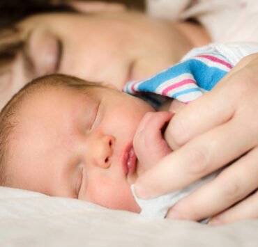 kobieta leży w szpitalu na pierwszym planie noworodek