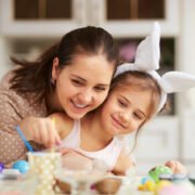 młoda mama z dzieckiem malują jajka na Wielkanoc