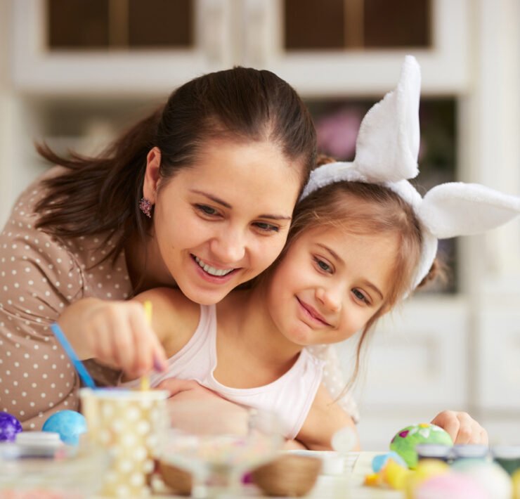 młoda mama z dzieckiem malują jajka na Wielkanoc