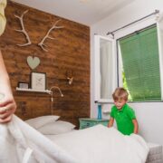 chłopiec pomaga mamie ścielić łóżko