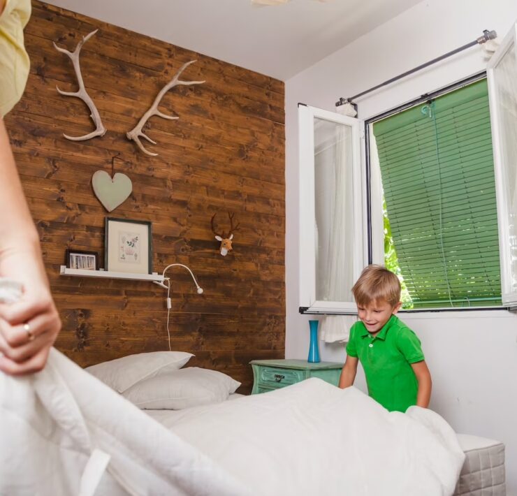 chłopiec pomaga mamie ścielić łóżko