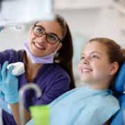 uśmiechnięta ortodontka z dzieckiem