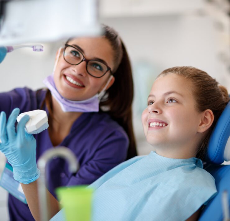 uśmiechnięta ortodontka z dzieckiem