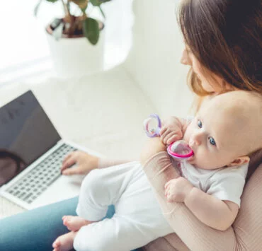 mama trzyma dziecko na rękach i sprawdza, jak dodać dziecko do IKP