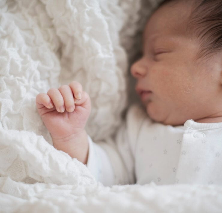 noworodek otulony kocykiem