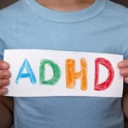 dziecko trzyma w ręku kartkę z napisem ADHD