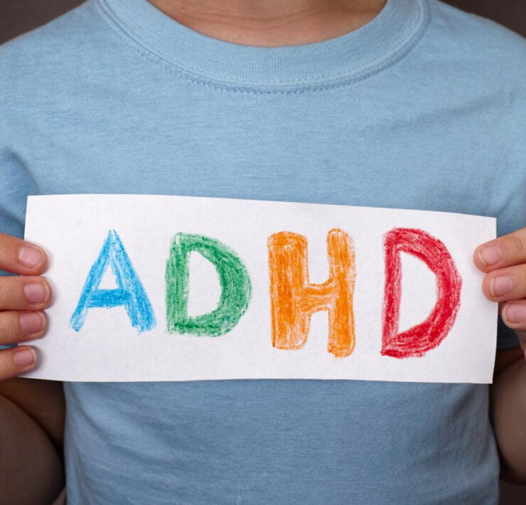 dziecko trzyma w ręku kartkę z napisem ADHD