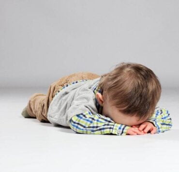 dziecko w złości leży na podłodze