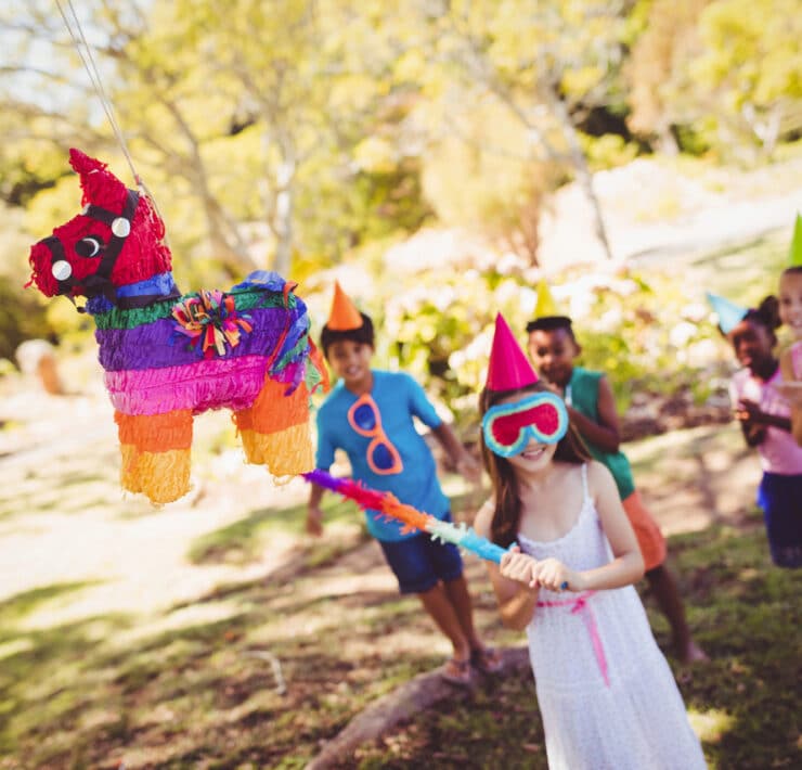 dzieci rozbijają piniatę w kształcie jednorożca