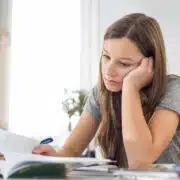 młoda dziewczyna ma problem z koncentracją siedzi nad książkami