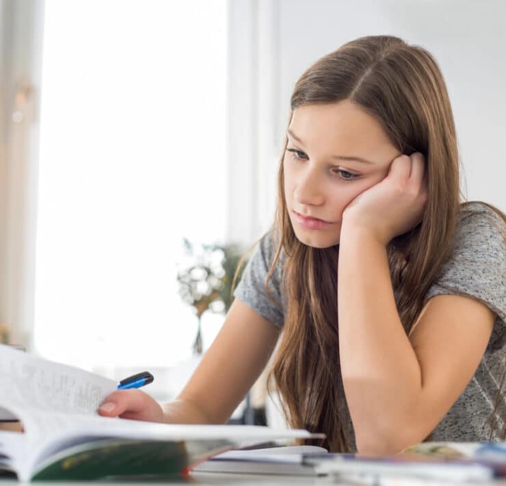 młoda dziewczyna ma problem z koncentracją siedzi nad książkami
