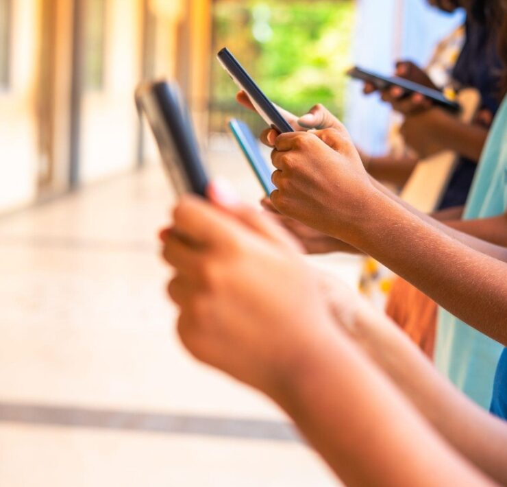 ręce dzieci z telefonami komórkowymi w dłoniach