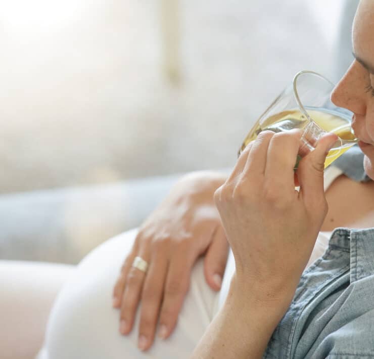 kobieta w ciąży pije ziołowy napar z melisy