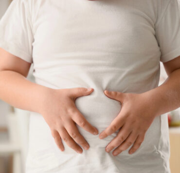 otyłe dziecko trzyma się za brzuch