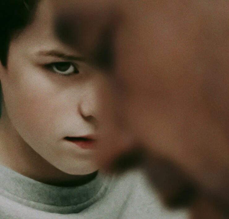 Plakat serialu „Adolescence” z zaniepokojonym chłopcem na pierwszym planie i częściowo widocznym dorosłym. U góry nazwiska aktorów, a na dole tytuł i informacja o premierze na Netflixie 13 marca.