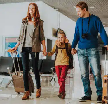 rodzina trzyma się za ręce na lotnisku z bagażem i dokumentami (paszport)