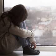 dziewczyna z fobią szkolną siedzi smutna na parapecie