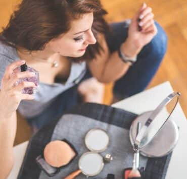 kobieta z perfumami damskimi przed sobą