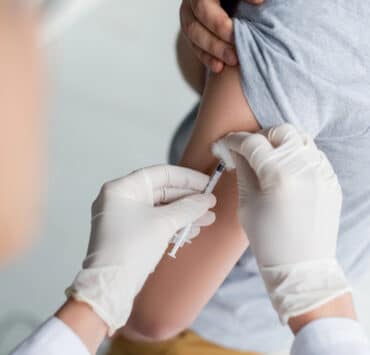 pielęgniarka szczepi dziecko na grypę