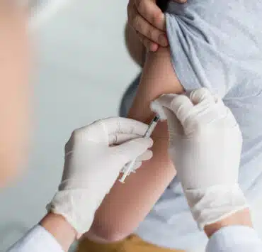 pielęgniarka szczepi dziecko na grypę