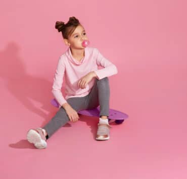 dziewczynka z gumą do żucia na różowym tle