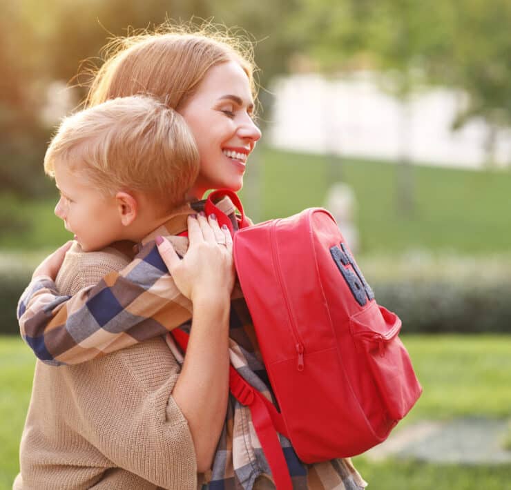 mama przytula dziecko przed pierwszą klasą szkoły podstawowej